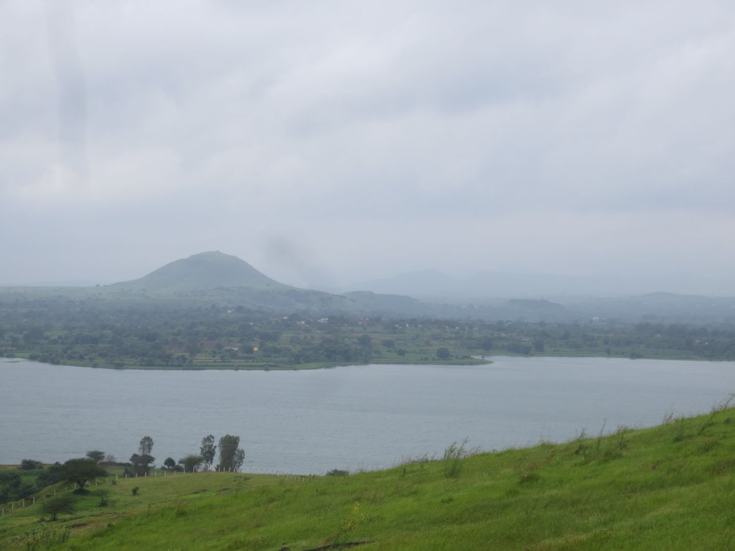 Green monsoon slope running down to the lake